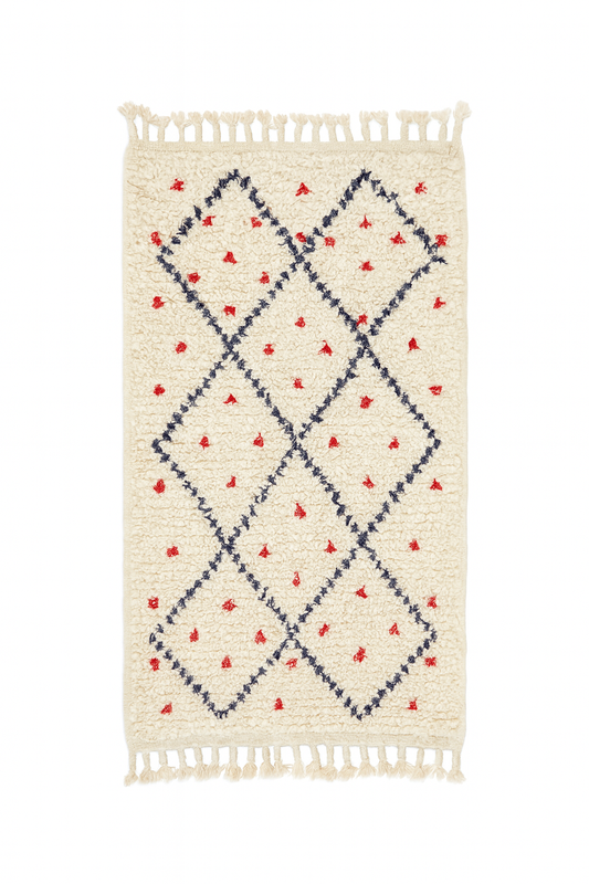 Handwoven Beni Ourain mini rug with ivory base, navy diamond lattice, and red dotted motifs.
