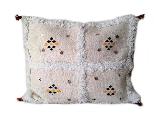 White Moroccan Berber pillow cover with quadrant design, black and yellow diamond embroidery, silver sequins, and fringe details, handmade from wool.