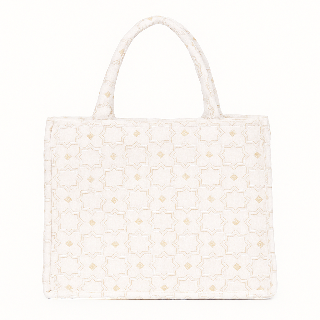 Ivory Moroccan brocade tote with geometric star motifs and short padded handles, featuring a structured silhouette and soft golden accents.
