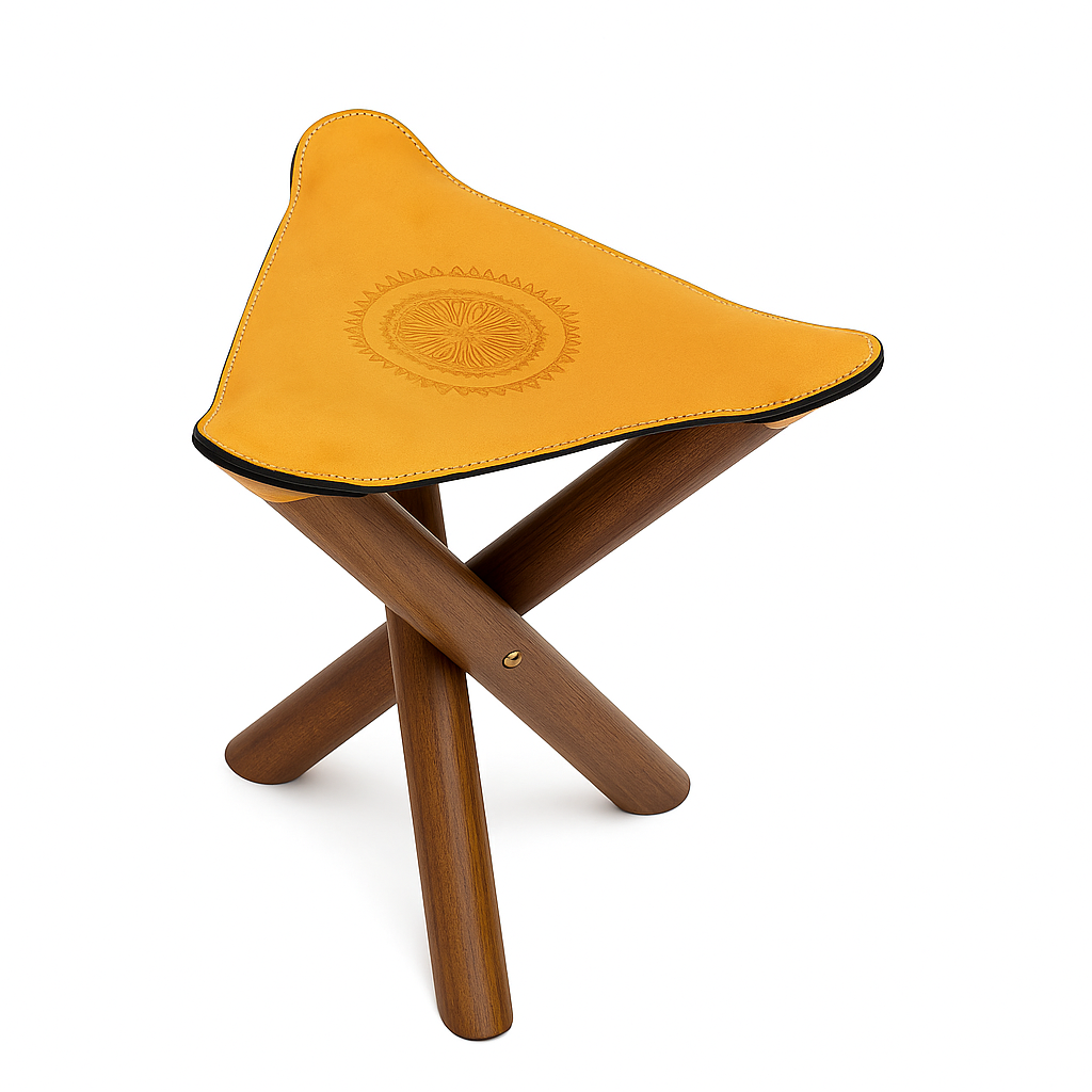 Handcrafted Moroccan stool with golden leather seat and dark wooden legs, inspired by traditional nomadic design.
