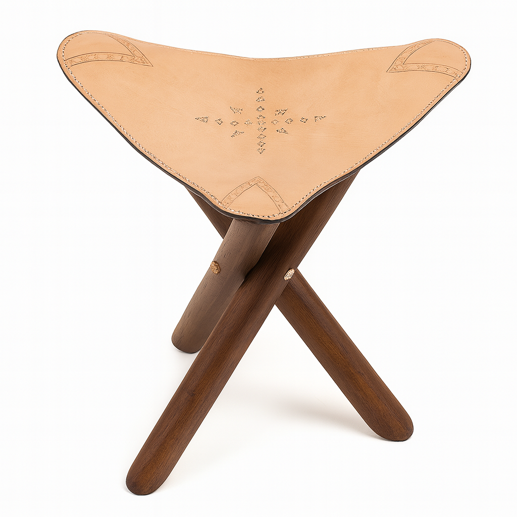 Handcrafted Moroccan leather tripod stool with tan embossed seat and dark wooden legs, artisan-made in Morocco.
