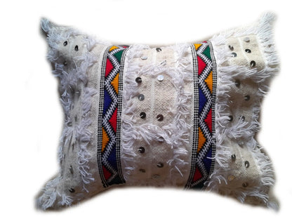 White Moroccan Handira pillow cover with colorful Berber embroidery, fringe texture, and silver sequins, handmade from wool and cotton